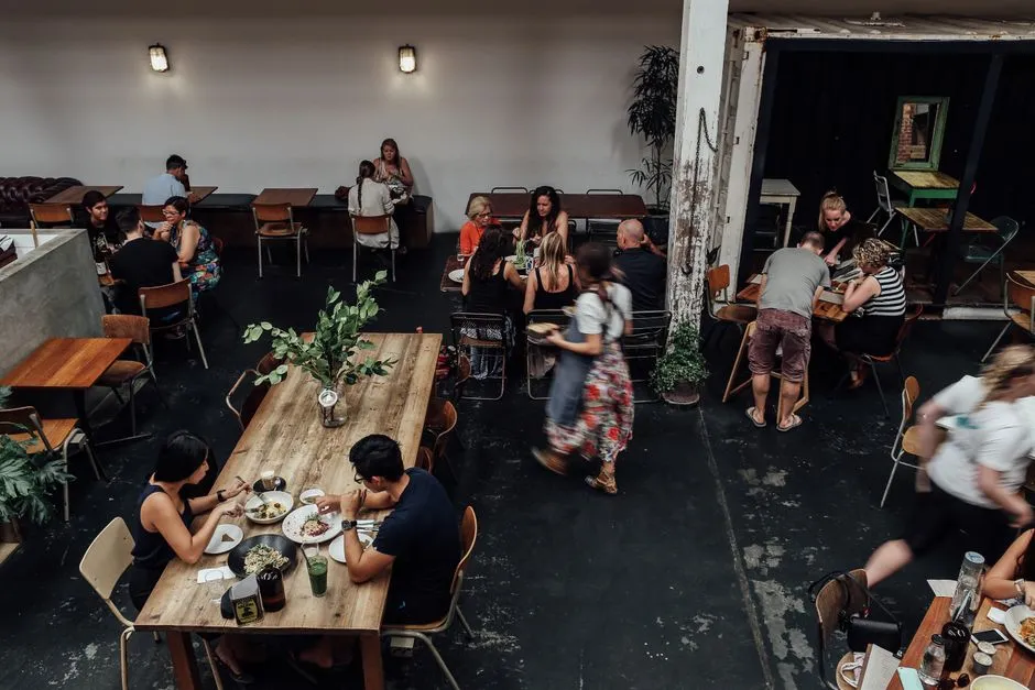 Diners eating and servers moving between tables in a busy casual restaurant